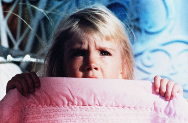 girl hiding under her blanket in Poltergeist